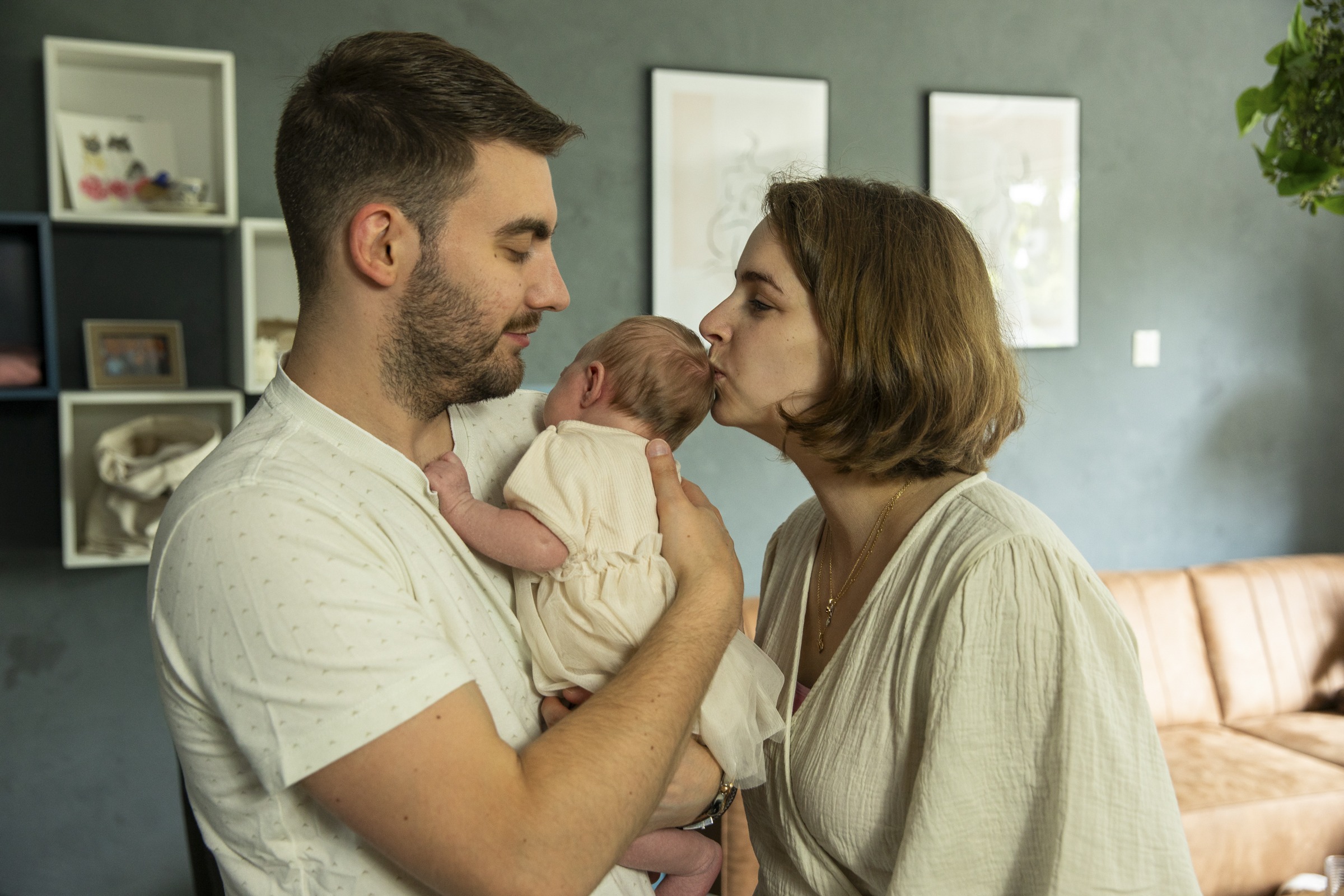 Vader en moeder kussen hun pasgeboren baby