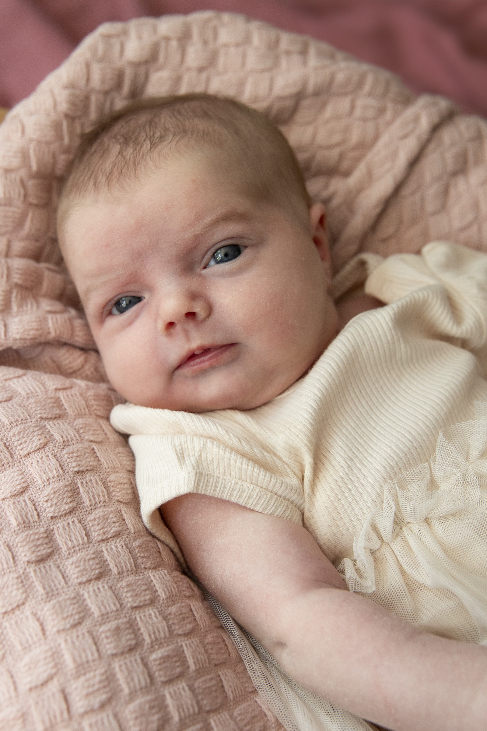 Babyshoot in de woonkamer, baby op een rose kleedje