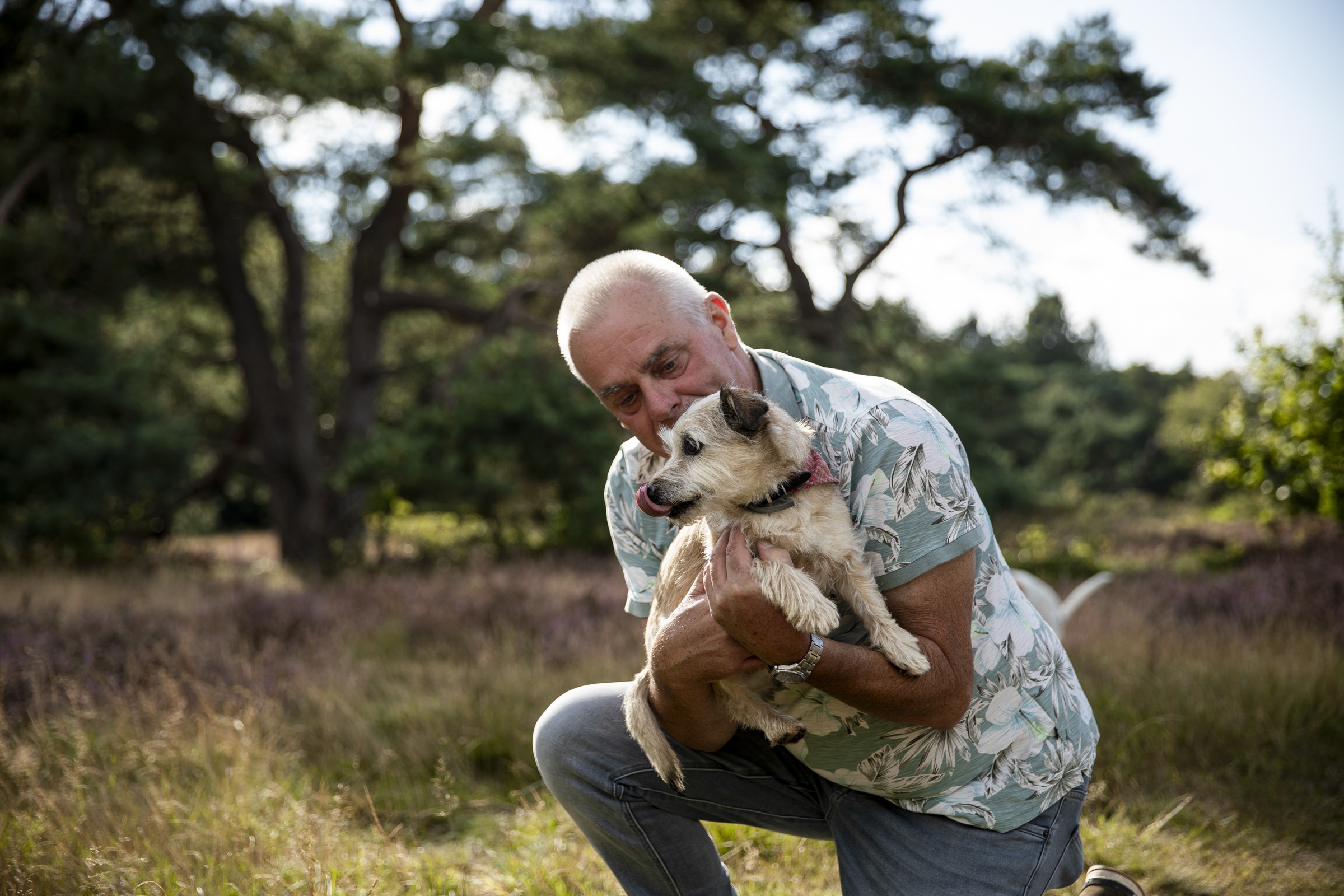 Man knuffelt met zijn hond in zijn armen