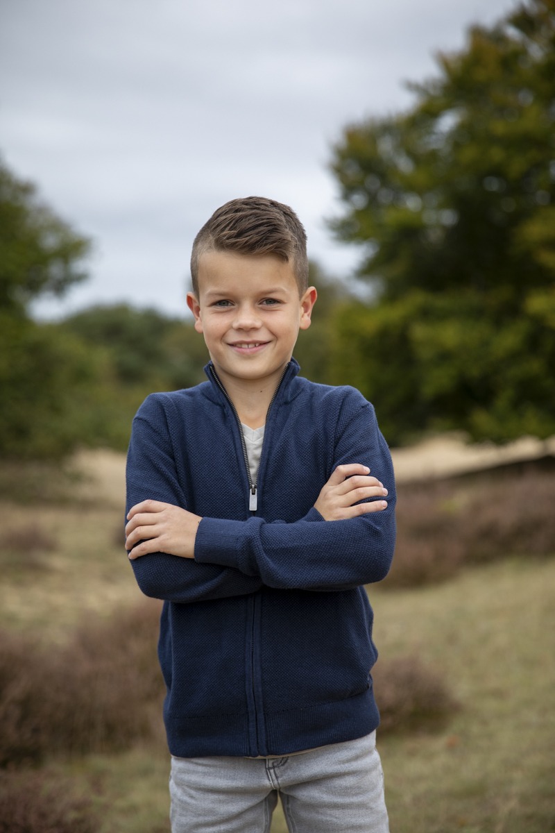Jongen met de armen over elkaar op de foto tijdens een fotoshoot